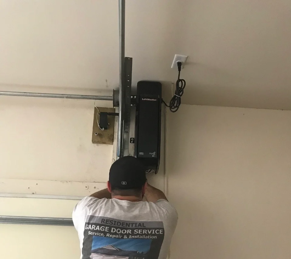 Technician performing Garage Door Opener Repair on garage door system in home.