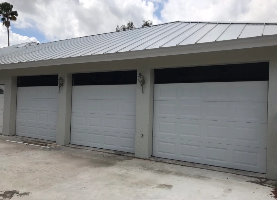 Technician performing Garage Door Panel Replacement on garage door system in home.