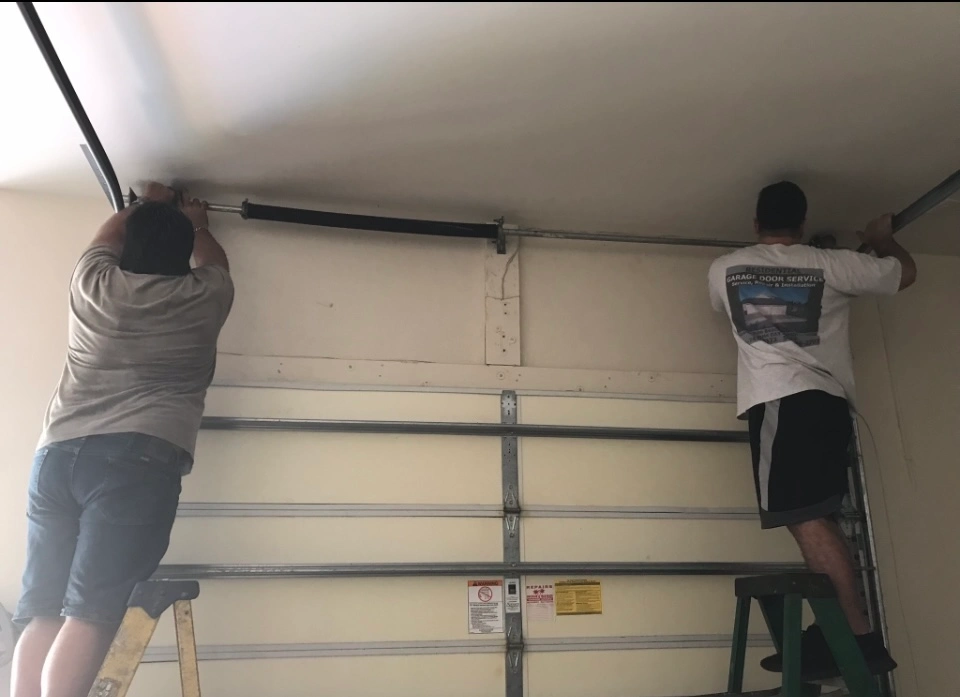 Technician performing Garage Door Repair on garage door system in home.