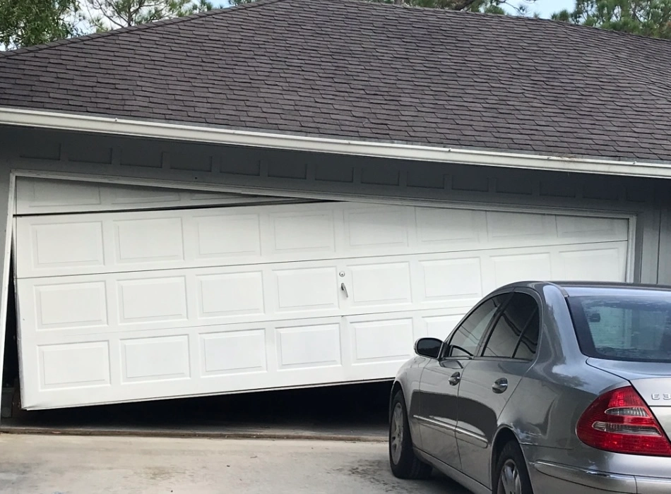 Technician performing Off-Track Garage Door Realignment on garage door system in home.