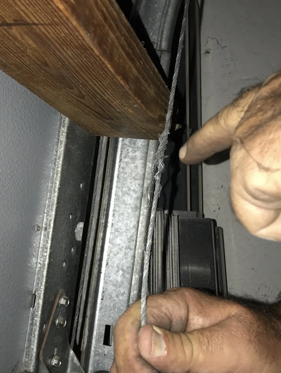 Close-up of a frayed garage door cable showing visible damage and wear